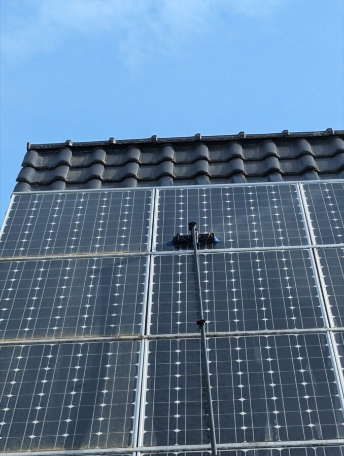 PV-Anlage auf Ziegeldach während der Reinigung mit Reinwasserbürste